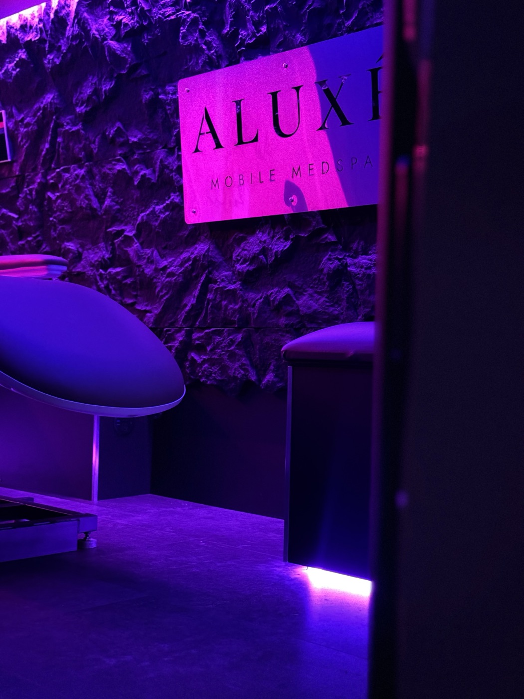 The ALUXÉ Mobile MedSpa sign inside the van